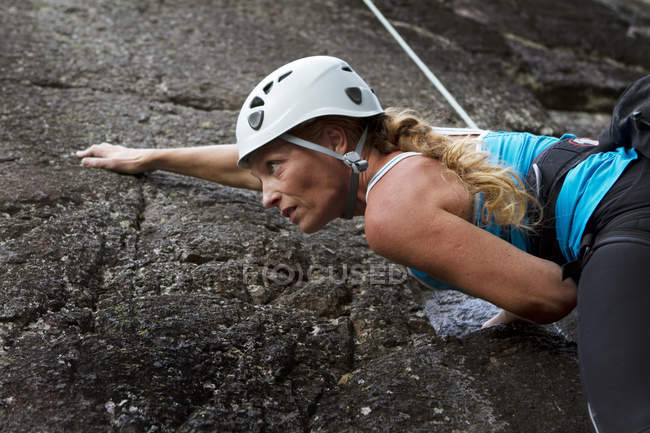 Femme escalade rocher, se concentrer sur le premier plan — Photo de stock