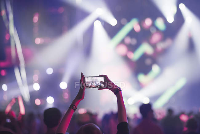 Mujer usando el teléfono inteligente en concierto, se centran en primer plano - foto de stock