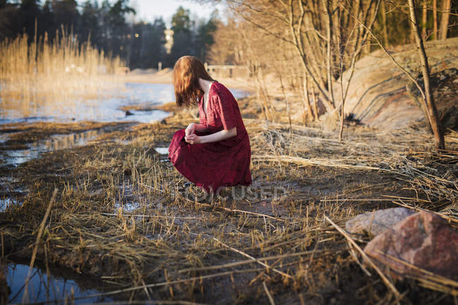 Mujer joven agachada en los humedales, enfoque selectivo - foto de stock