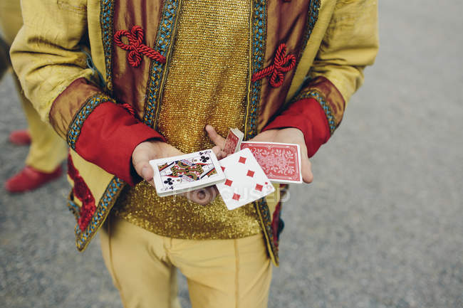 Mid section of circus performer holding cards — Stock Photo