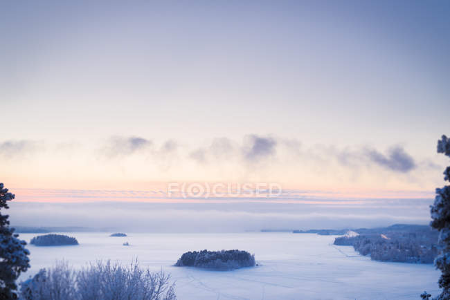 Malerischer Blick auf die Landschaft mit gefrorenem See in der Dämmerung — Stockfoto