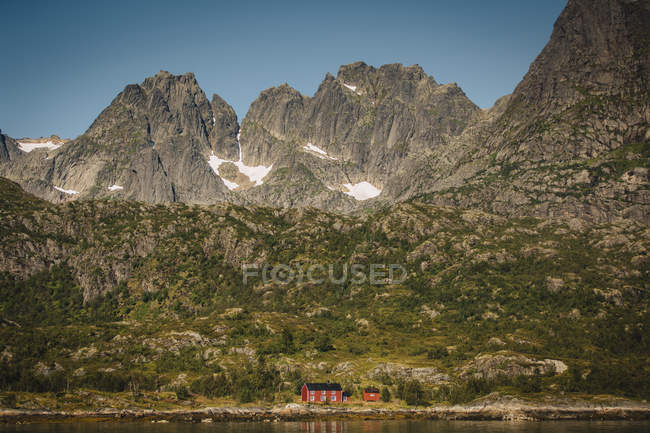 Paisagem de montanha e cabana de madeira por lago — Fotografia de Stock