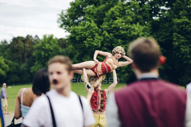 Acróbatas de circo jóvenes actuando en el parque - foto de stock