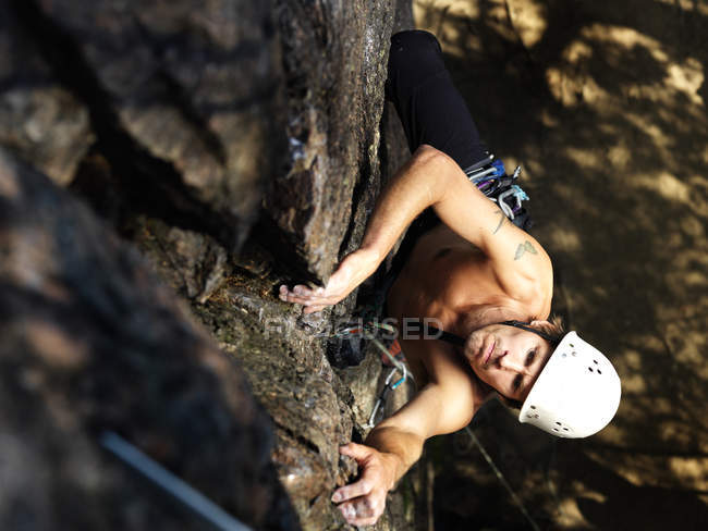 Hombre escalando roca, enfoque diferencial - foto de stock