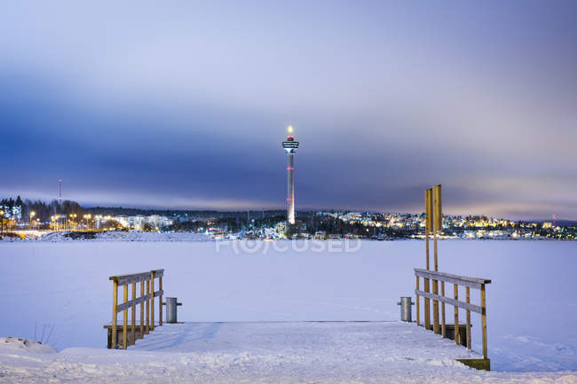Winter scene with frozen lake and communication tower — Stock Photo