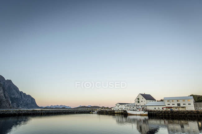 Edifici sulla costa al tramonto, riflessione in acqua — Foto stock