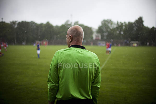 Visão traseira do árbitro em pé no campo de futebol — Fotografia de Stock