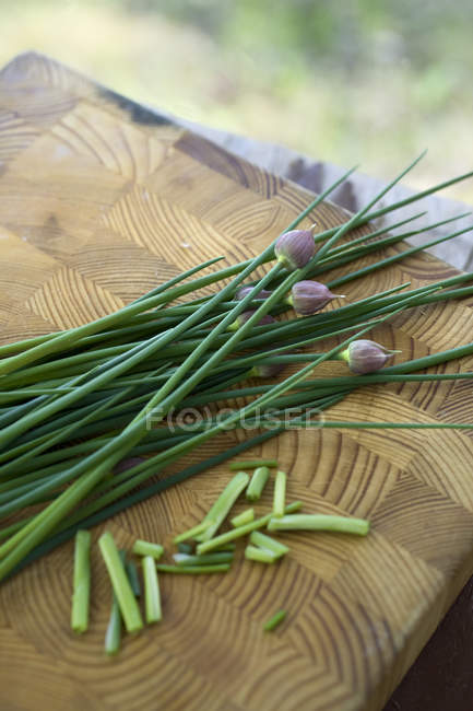 Fresh picked chives on cutting board — Stock Photo