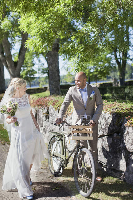 Newly wed couple with bicycle, focus on foreground — Stock Photo