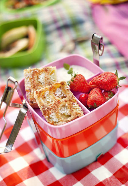 Caja con fresas y rodajas de tarta de manzana, enfoque selectivo - foto de stock