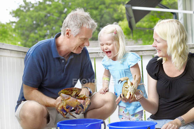 Portrait of grandparents and girl with crabs, selective focus — Stock Photo