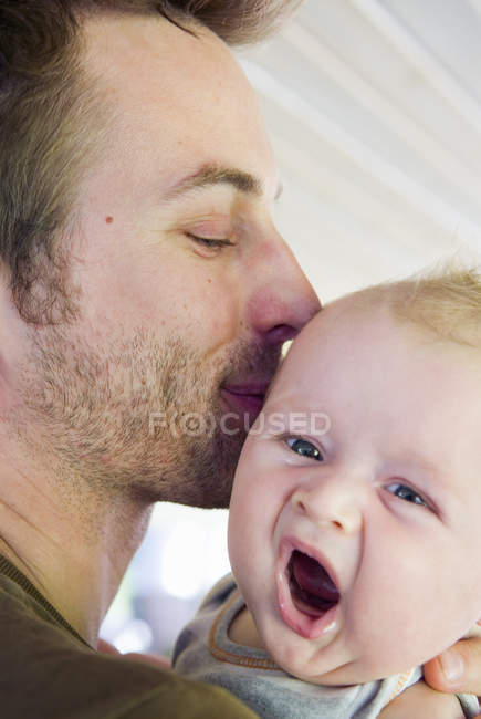 Portrait of father holding baby boy, focus on foreground — Stock Photo