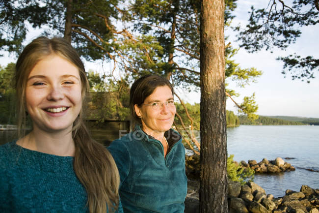 Portrait of mother and daughter on lake, focus on foreground — Stock Photo
