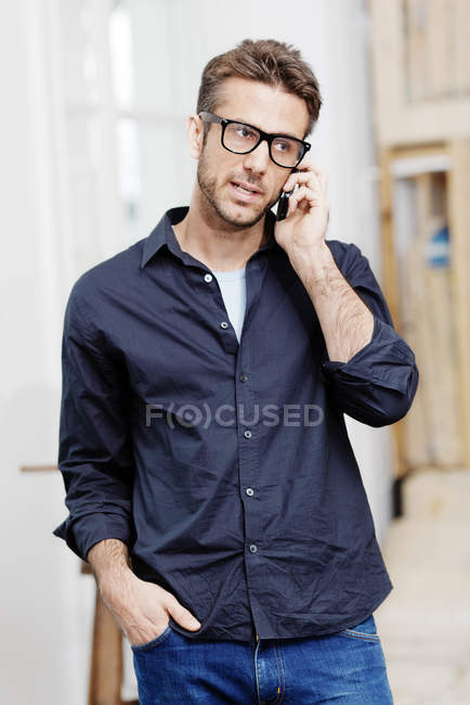Uomo d'affari che parla al telefono con la mano in tasca — Foto stock