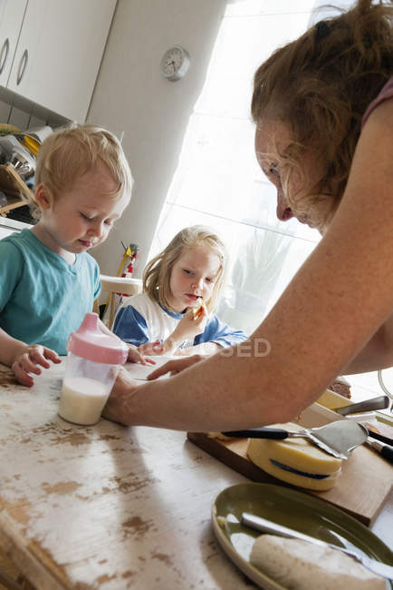 Mãe com filhos na cozinha, foco seletivo — Fotografia de Stock