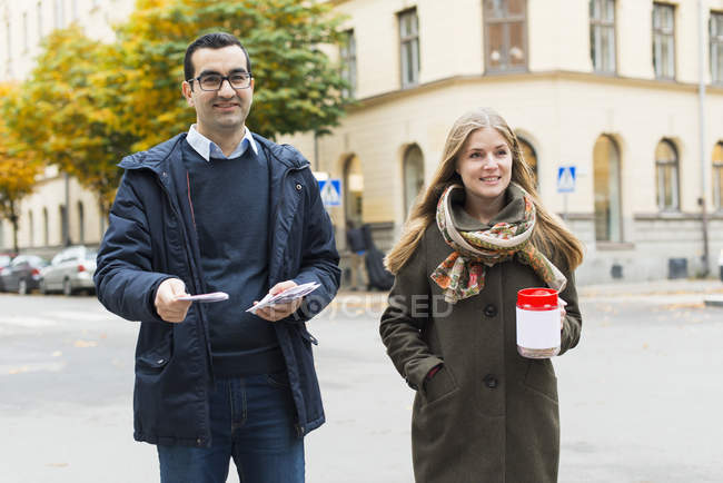 Portrait of charity volunteers at street, focus on foreground — Stock Photo