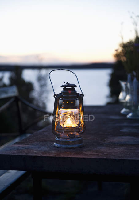 Lanterna na mesa ao entardecer, foco em primeiro plano — Fotografia de Stock