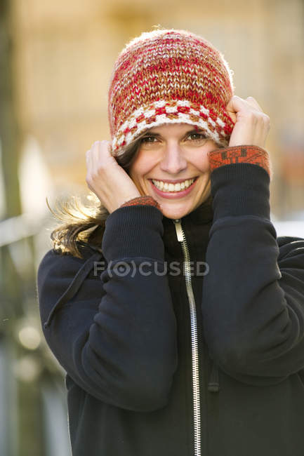 Портрет молодой женщины в вязаной шляпе и улыбающейся — стоковое фото