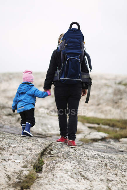 Vue arrière de la mère avec sa fille randonnée — Photo de stock