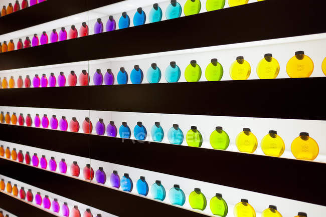 Вигляд спереду різнокольорові пляшок на полицях — стокове фото
