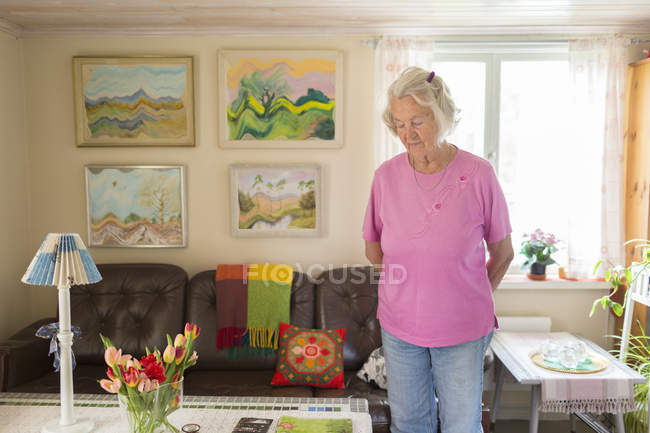 Пожилая женщина смотрит на журнал на столе — стоковое фото