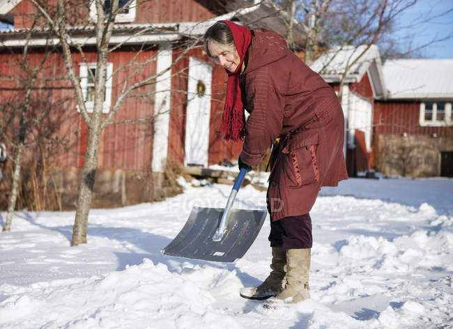 Жінка очищає сніг, вибірковий фокус — стокове фото