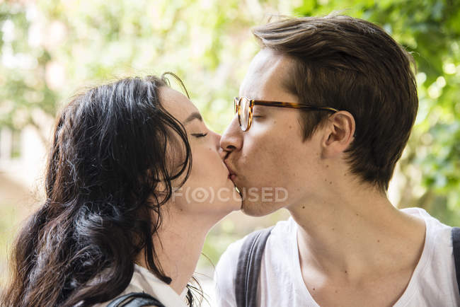 Young couple kissing, focus on foreground — Stock Photo
