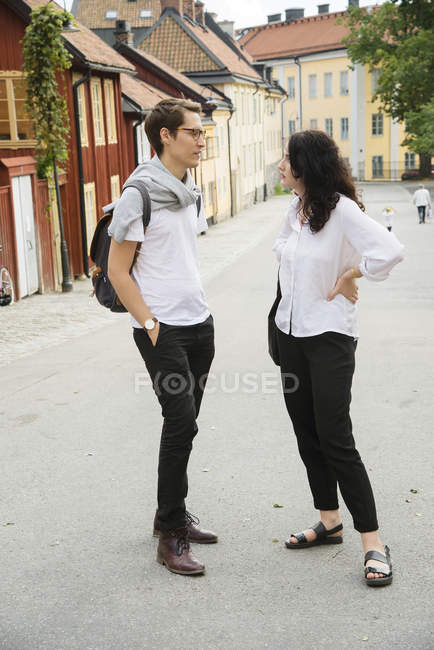 Молодая пара разговаривает на улице, фокусируется на переднем плане — стоковое фото