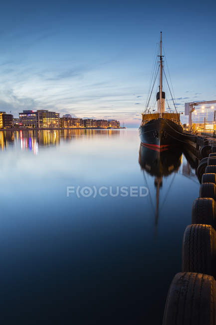 Navio amarrado e paisagem urbana iluminada no fundo — Fotografia de Stock
