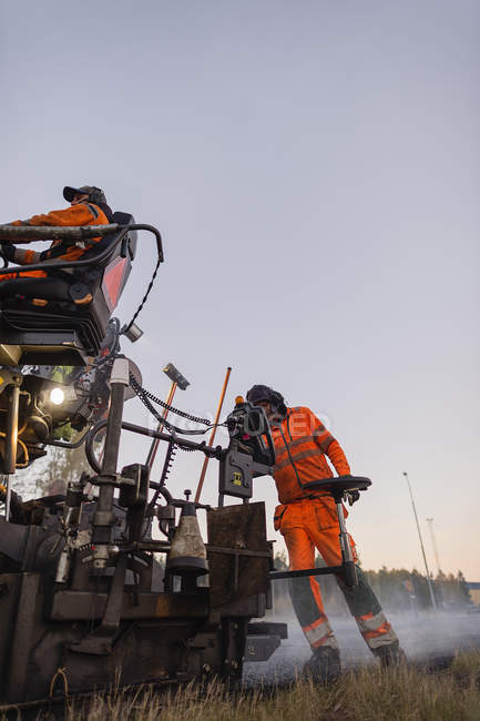 Ручні працівники ремонтують дороги на заході сонця — стокове фото