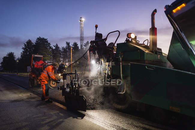 Dois trabalhadores manuais reparando estrada, foco seletivo — Fotografia de Stock