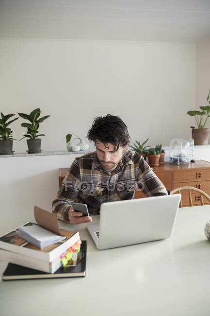 Mittlerer erwachsener Mann nutzt Smartphone zu Hause — Stockfoto