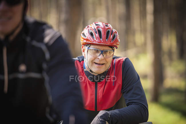 Mature men in cycling helmets forest — Stock Photo
