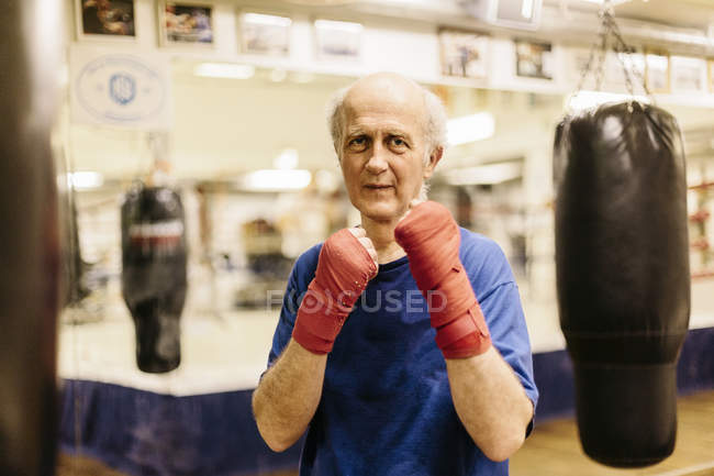 Senior man with fists raised at boxing training — Stock Photo