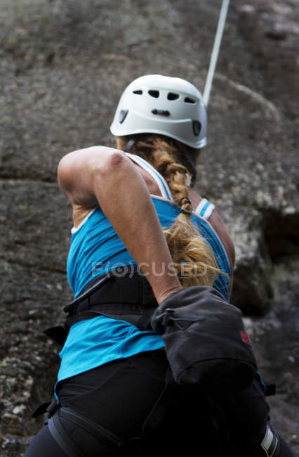 Задний вид женщины, карабкающейся по скале — стоковое фото
