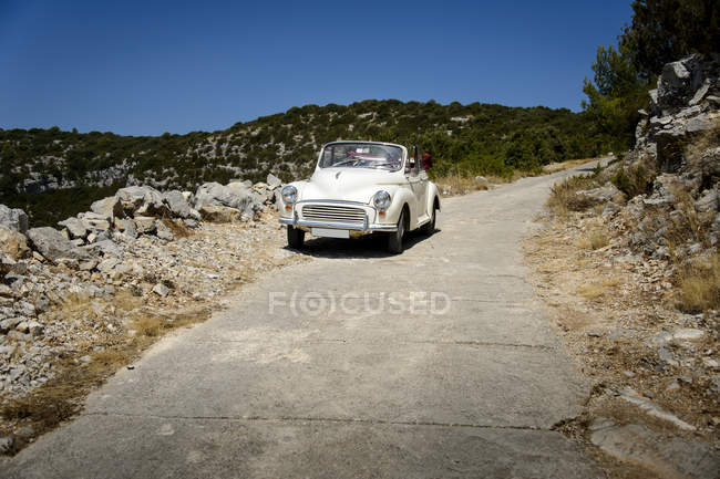 Vieille voiture sur la route de montagne en été — Photo de stock