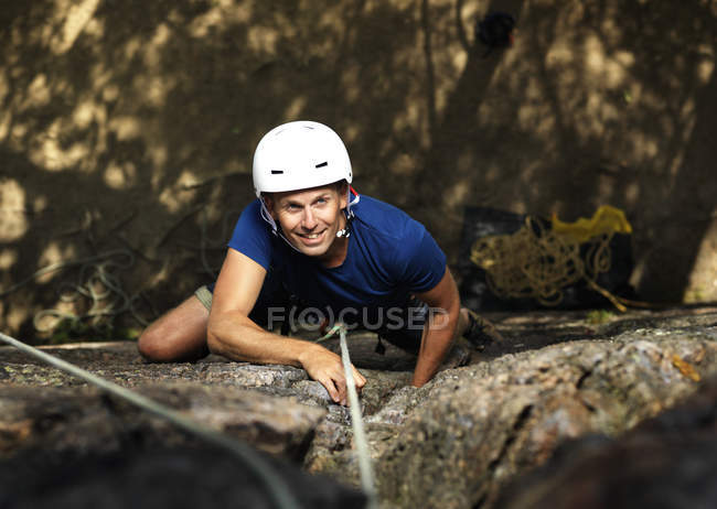 Uomo sorridente arrampicata su roccia, focus selettivo — Foto stock