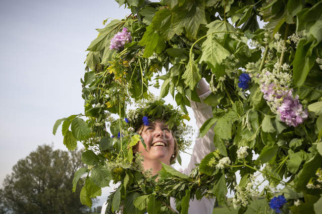 Женщина устраивает цветочный венок для празднования середины лета — стоковое фото
