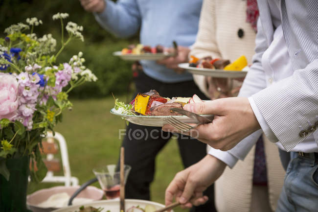 People eating food during midsummer celebrations — Stock Photo
