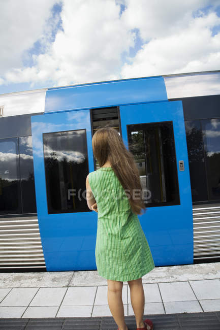 Ragazza adolescente in piedi sulla piattaforma della stazione ferroviaria — Foto stock