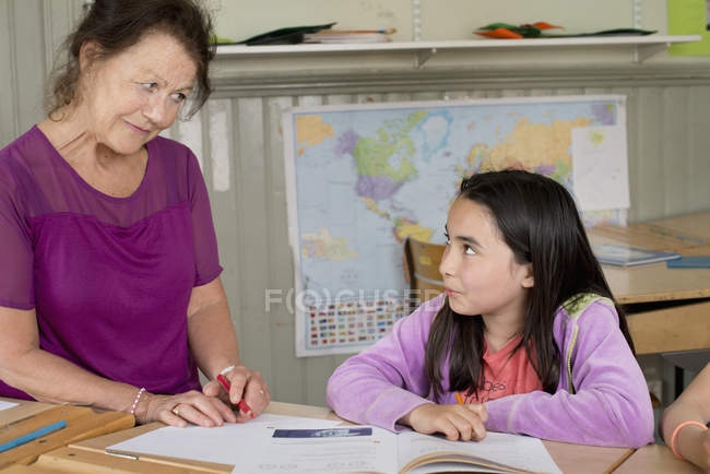 Teacher looking at girl, focus on foreground — Stock Photo