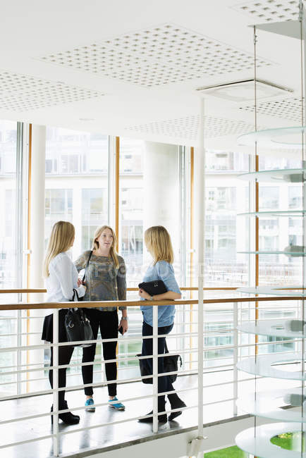 Estudantes do sexo feminino se comunicando no interior da universidade — Fotografia de Stock