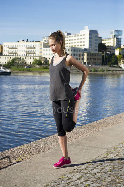 Жінка в спортивному одязі тренується вздовж набережної — стокове фото