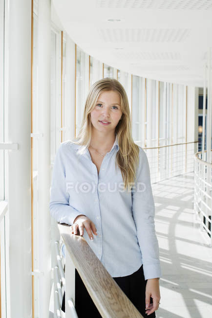Portrait of young woman at university interior — Stock Photo