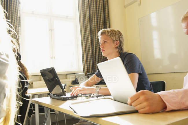 Молодий чоловік використовує ноутбук у класі — стокове фото