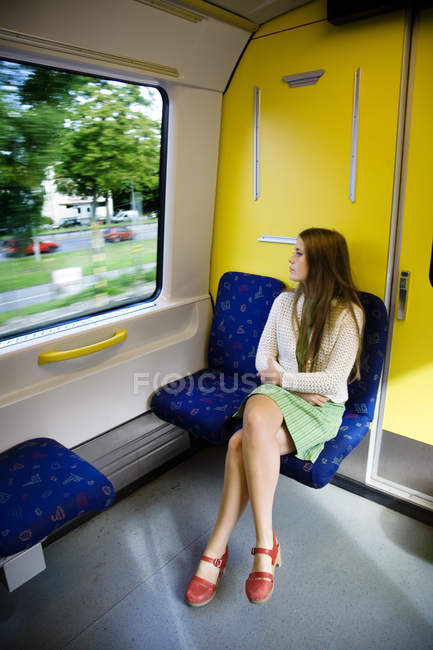 Teenage girl looking through window at train — Stock Photo