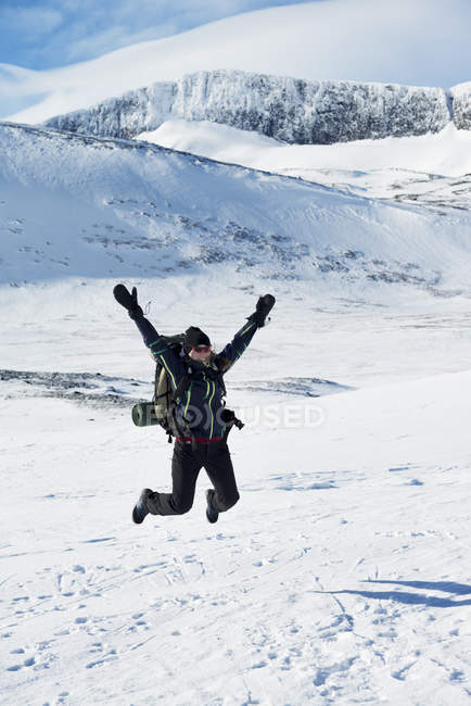 Tourist jumping in winter landscape in Harjedalen, Sweden — Stock Photo