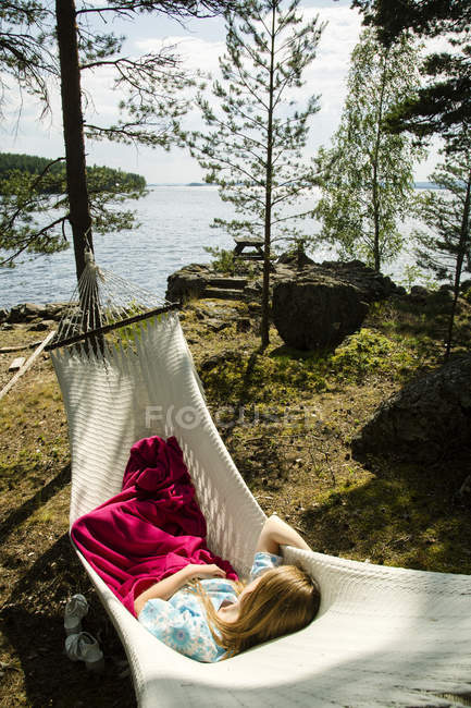 Young woman lying on hammock in forest — Stock Photo