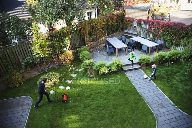 Father and two sons working at backyard garden — Stock Photo