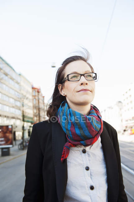 Жінка з коричневим волоссям, в окулярах дивиться вдалину — стокове фото